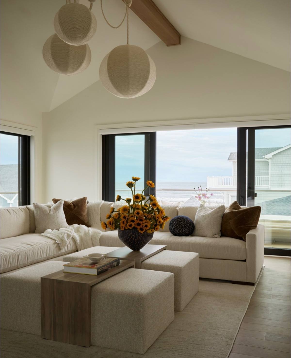 Living room with paper lantern pendants and sunflowers before an ocean view