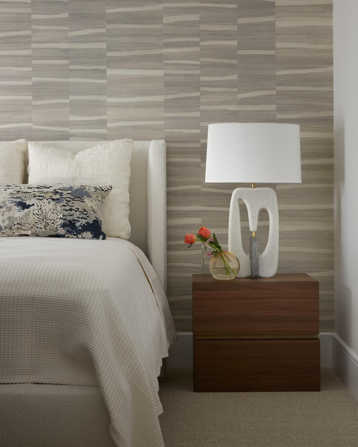 Bedroom with grasscloth wallcovering and layered textural pillows