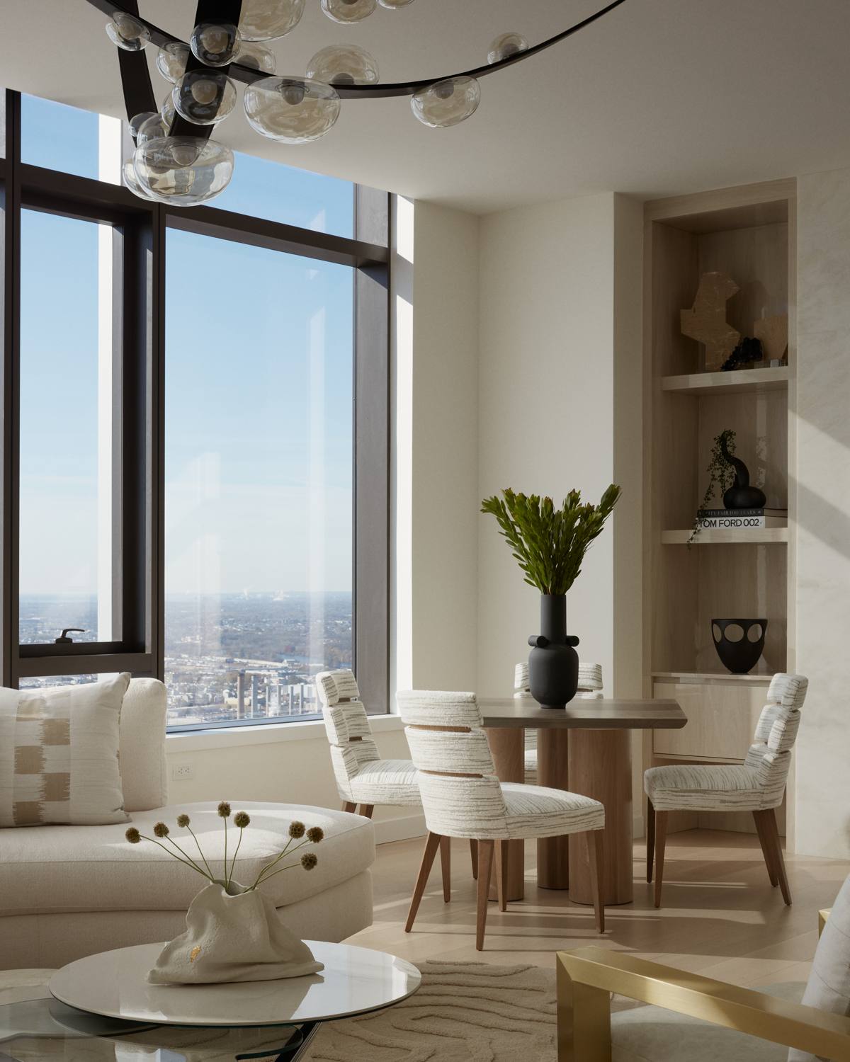 Dining corner at The Laurel with sculptural upholstered chairs and styled built-in shelving